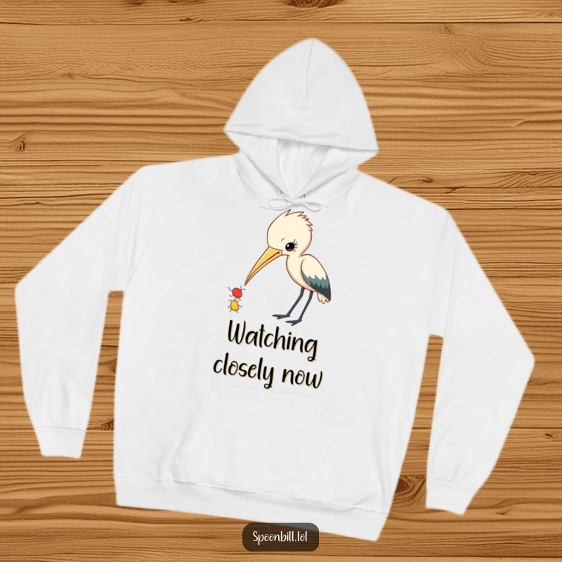 Funny Spoonbill Hoodie: A curious spoonbill character with beak slightly ajar observes a small insect, offering cozy humor.
